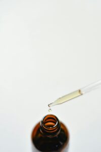 Close-up of a brown glass dropper bottle with a droplet, perfect for essential oils or medicine use.